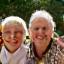 A smiling multi-generational family portrait against a backdrop of lush nature.