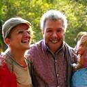 The Johnson Family (parents and two children) laughing joyfully during an outdoor activity