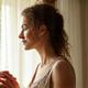 Portrait of a glowing new mother, early 30s, holding a cup of tea, appearing calm and centered.